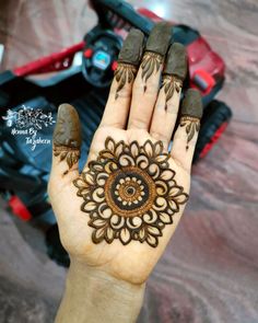 a woman's hand with henna tattoos on it