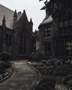 an old building with many windows and flowers in the front yard