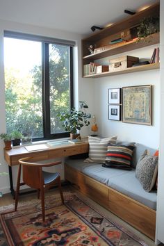 a living room with a couch, desk and bookshelf next to a large window