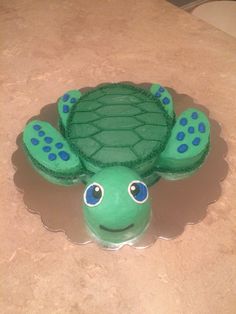 a green turtle cake sitting on top of a counter