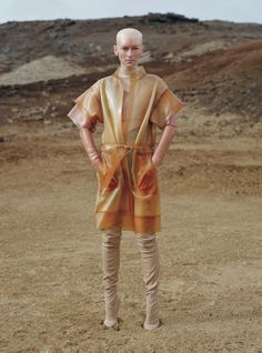 a woman standing in the middle of a desert