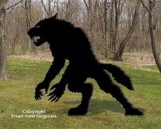 a bigfoot standing in the grass near some trees