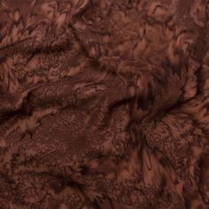 an animal print fabric with brown and black patterns on the top, in very dark colors