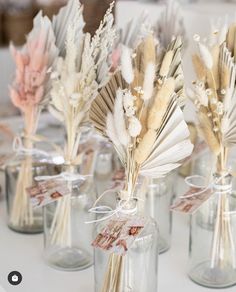 small vases with dried flowers in them on a table