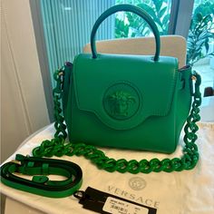 Versace - La Medusa Small Handbag In Green. La Medusa Handbags Are Made In Italy From Premium Leather Sourced From Italian Tanneries. The Soft Texture And Relaxed Construction Creates A Slouchy Finish. Style: Dbfi040_dvit2t_1g57v * La Medusa Plaque * Top Handle * Leather Shoulder Strap * Chain Shoulder Strap * Magnetic Button Closure * Flat Internal Pocket * Outer Fabric: 100% Leather * Lining: 100% Leather * Made In Italy New With Tags & Dust Bag. Never Worn. L7.9" X W3.9" X H2.3" Strap: L70-11 Versace Bags, Small Handbags, Chain Strap, Soft Textures, Versace, Dust Bag, Shoulder Strap, Bag Lady, Handbags