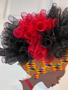 a red and black flower arrangement in a yellow basket on a white door frame with a woman's profile behind it