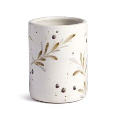 a white vase with gold leaves and dots on it's rim, against a white background