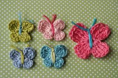 four crocheted butterflies sitting on top of a table