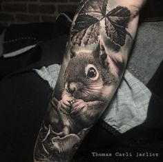 a man's arm with a squirrel and leaves on it