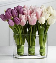 a vase filled with pink and white tulips