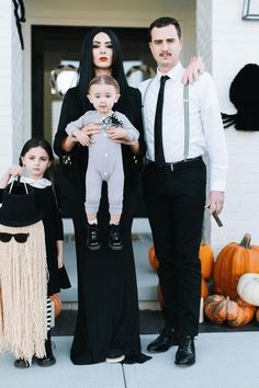 a family dressed up for halloween standing in front of their house