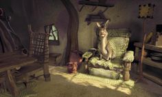 a rabbit sitting on top of a green chair in a room filled with wooden furniture