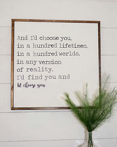 a vase filled with green plants sitting next to a framed sign that reads and i'd choose you in a hundred lifelines, in a hundred words