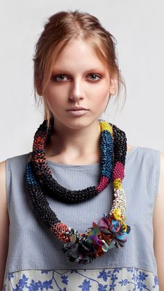 a woman wearing a multicolored necklace with flowers on the front and back of her neck