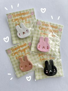 three bunny shaped magnets sitting on top of each other in plastic bags with the words handmade clay market printed on them