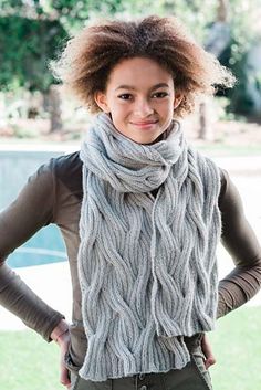 a woman standing with her hands on her hips and wearing a scarf over her shoulders