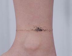 a small tattoo on the ankle of a woman