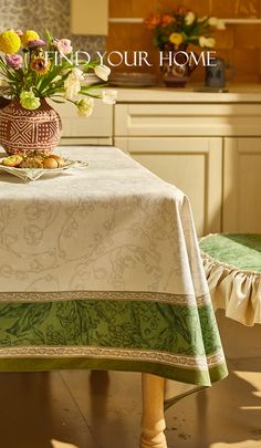 a vase with flowers sitting on top of a table next to a green chair in a kitchen