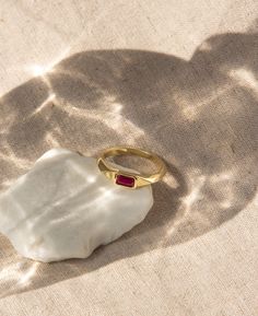 Channel an old-world glamour with our Winnie Baguette CZ Signet Ring. Made of 14k gold fill, the vintage-flair ring is embedded with a striking red ruby baguette-cut cubic zirconia stone that shines beautifully on the hand. Perfectly sized for everyday wear, this whimsical signet ring will instantly upstyle any outfit. It's unique enough to wear alone, or with other stackable gold rings in our collection. THE LOVE COLLECTION Remember those times when you were madly in love? Remind yourself how well you looked and felt. Be the sparkle that enchants your loved one this Valentine's day with our Love Collection. Inspired by vintage gold jewelry, this collection feature timeless staples that takes you back to the beginning ranging from vintage heart shape charm necklaces to gleaming ruby cz sig Ruby Signet Ring, Signet Ring Vintage, Ring Baguette, Gold Rings Stackable, Gold Filled Ring, Red Band, Vintage Heart, Ring Vintage, Cz Stone