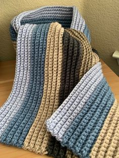 Crocheted blue, tan and brown cozy scarf. Cozy Blue Scarf For Fall, Cozy Blue Scarves For Fall, Brown Casual Scarves For Cold Weather, Casual Brown Scarves For Cold Weather, Cozy Blue Scarf One Size, Warm Brown Scarf For Cold Weather, Warm Brown Scarves For Cold Weather, Brown Scarf, Brown Scarves