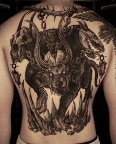 the back of a man with tattoos on his body and two horned animals in front of him