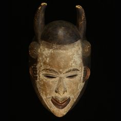 an old mask with horns on it's head is shown against a black background