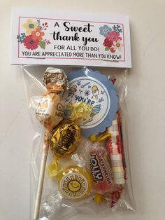 a candy bag filled with assorted candies on top of a white table next to a thank you sign