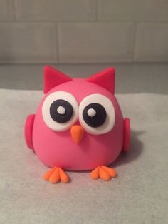 a pink owl with big eyes sitting on top of a counter