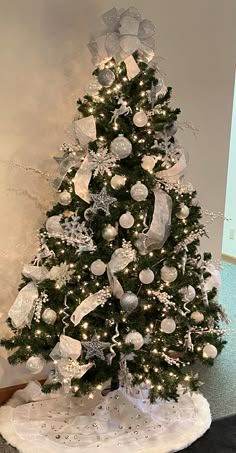 a decorated christmas tree with white and silver ornaments