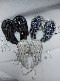 three pairs of black, silver and white beaded jewelry laying on top of each other