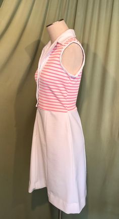 "This is a cute vintage dress from the early 70s. No Brand label only a care & size tag. Tagged a size 14. The bust measures 36\", waist 30\", see measurements below, but it would look best on a slightly smaller bust & waist. Made of a pink & white polyester. The dress is a zip & button front shirt dress. It buttons to the waist & below that is a short nylon zipper. It is sleeveless with a lapel style collar. The top half is pink & white horizontal stripe & the skirt Vintage White A-line Sleeveless Dress, White Retro Sleeveless Spring Dress, White Retro Sleeveless Dress, White Sleeveless Mod Dress, Sleeveless Mod Dresses For Daywear, Button Front Shirt Dress, Design Clothes, Brand Label, Fashion Design Clothes