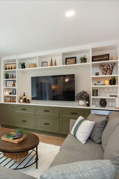 a living room filled with furniture and a flat screen tv mounted on a wall above it