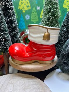 a red shoe sitting on top of a wooden table next to christmas trees and other decorations