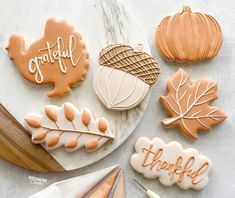 decorated cookies on a marble platter with fall leaves