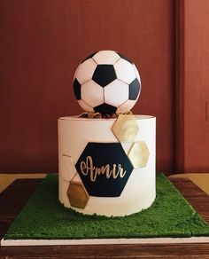 a soccer themed birthday cake with a soccer ball on top