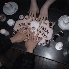 two hands on top of a cake surrounded by candles and tea cups, with the words abcde ukm next to it