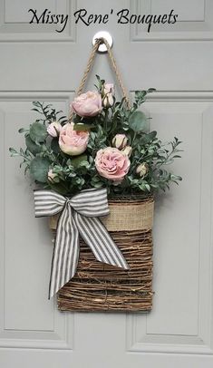 a basket with flowers hanging on the front door