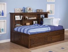 a bedroom with a bed, bookcases and pictures on the wall above it