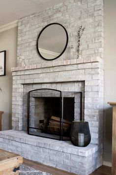 a living room with a fire place and mirror on the wall above it's mantle