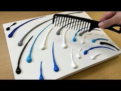 a person is cutting out toothbrushes on a board with blue and white tips