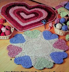 a crocheted heart shaped rug next to other items