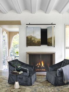 a living room with two chairs and a fire place