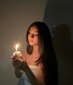 a woman holding a lit candle in her hand