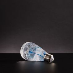 a light bulb that is sitting on a table with a black surface in front of it