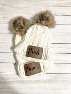 a white beanie with two brown pom - poms on it and the word mimi