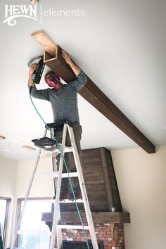 a man standing on a ladder working on a beam