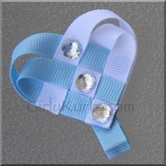 a blue and white heart shaped brooch with two small buttons on it's side