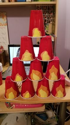 a stack of red cups sitting on top of a wooden table