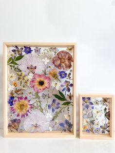 two wooden frames with pressed flowers on them