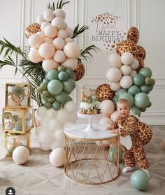 a giraffe themed birthday party with balloons, cake and baby's first birthday